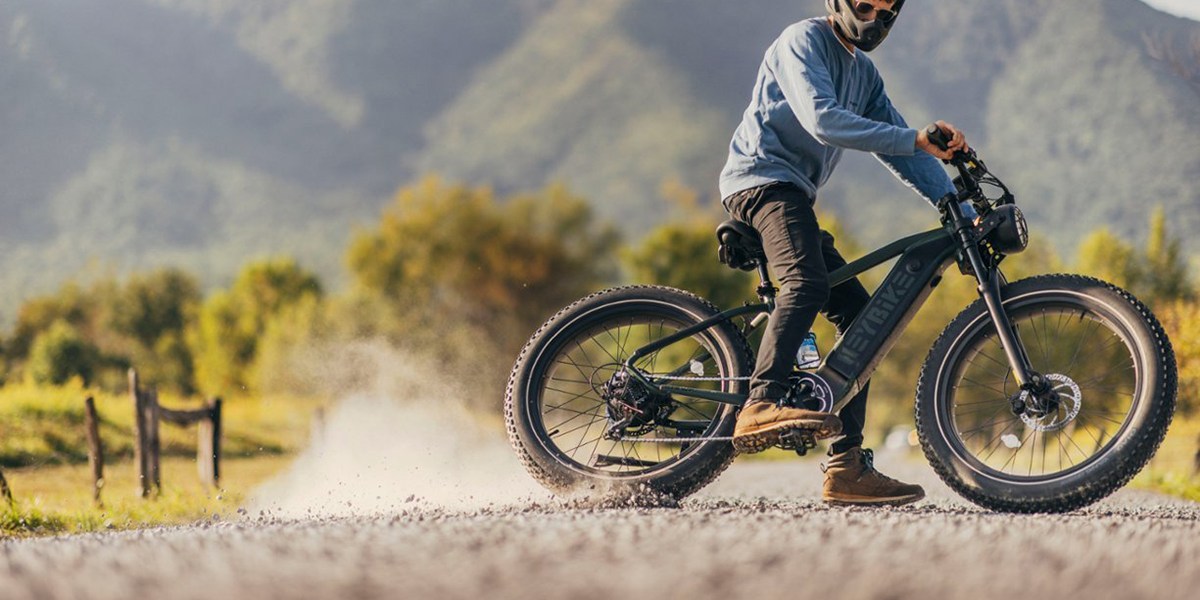 a man riding a motorcycle down a dirt road